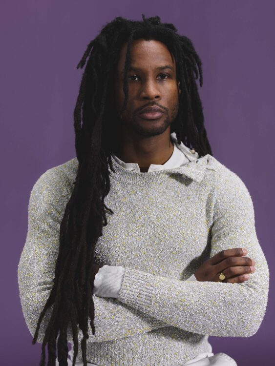 Akinola Davies Jr folds his arms and looks straight ahead in Bottega Veneta