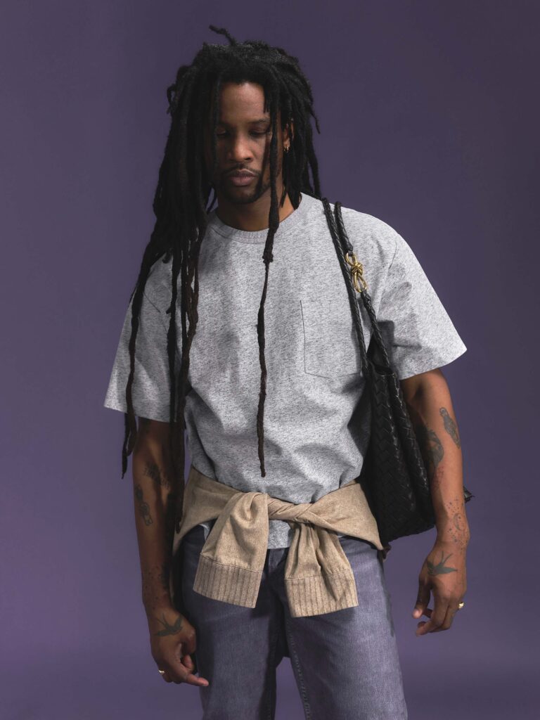 Akinola poses in a casual Bottega Veneta look against a purple background