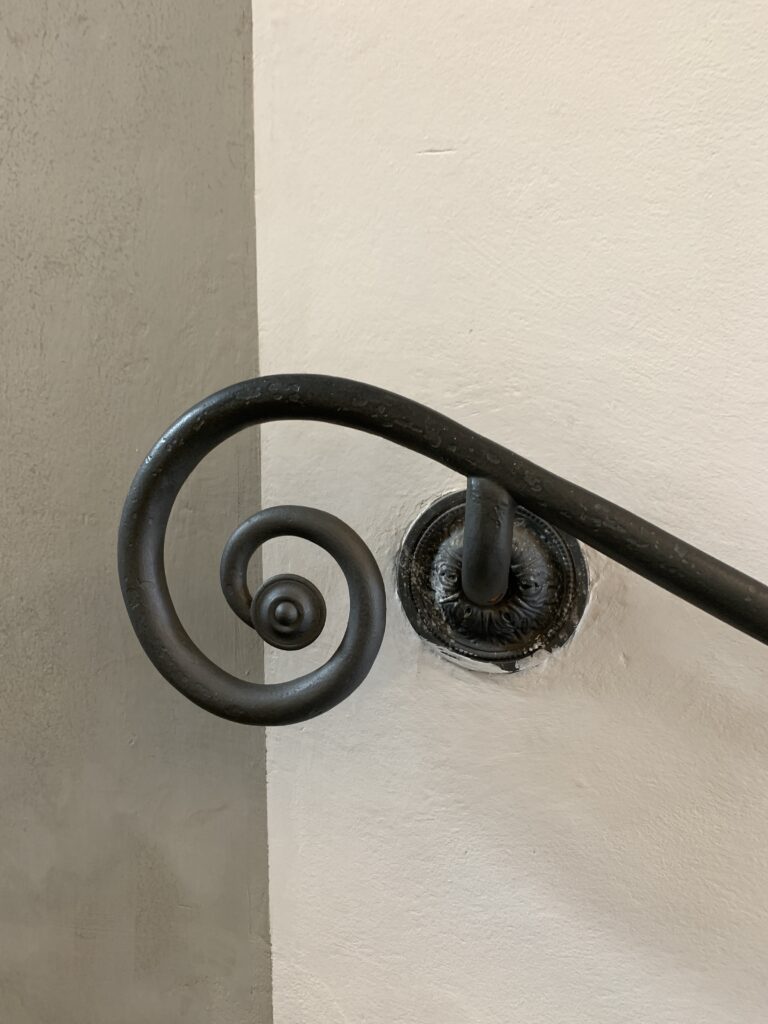Close-up of a curled end of a metal banister rail